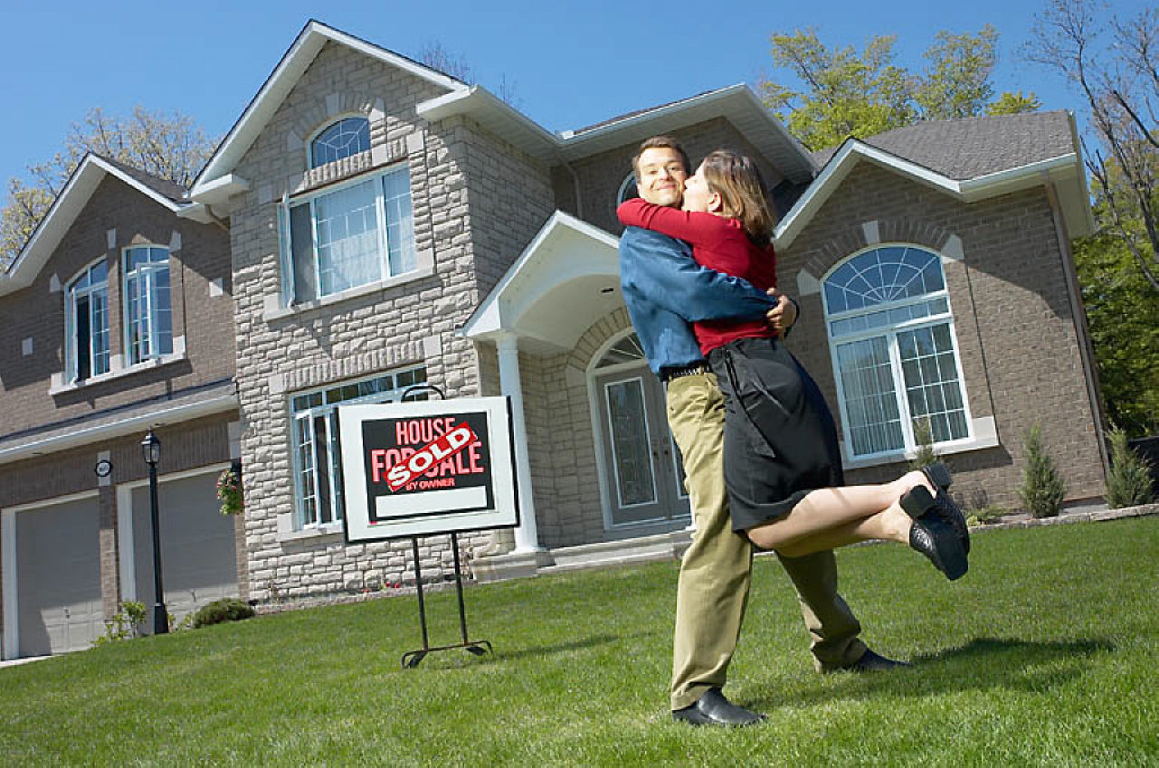 Embracing young couple who have just bought a house
